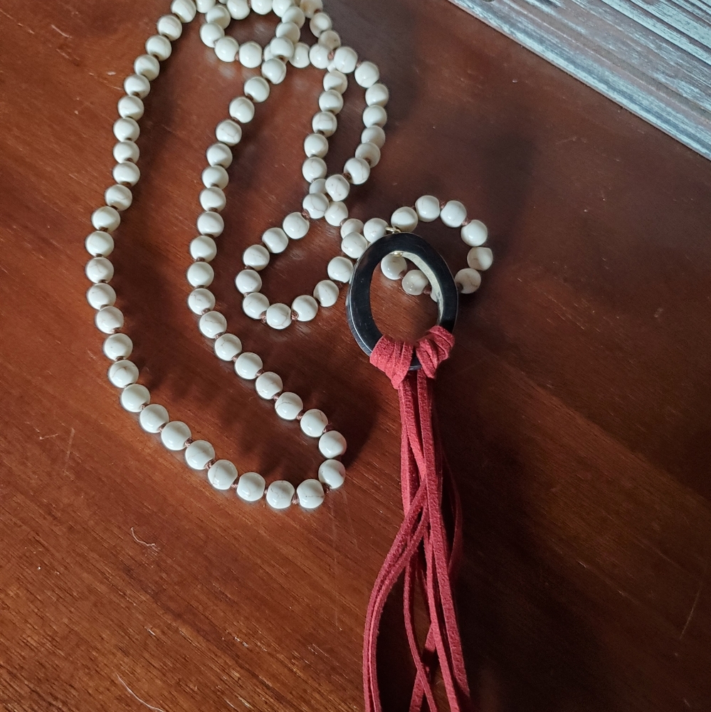 Long wood bead necklace with leather tassel.